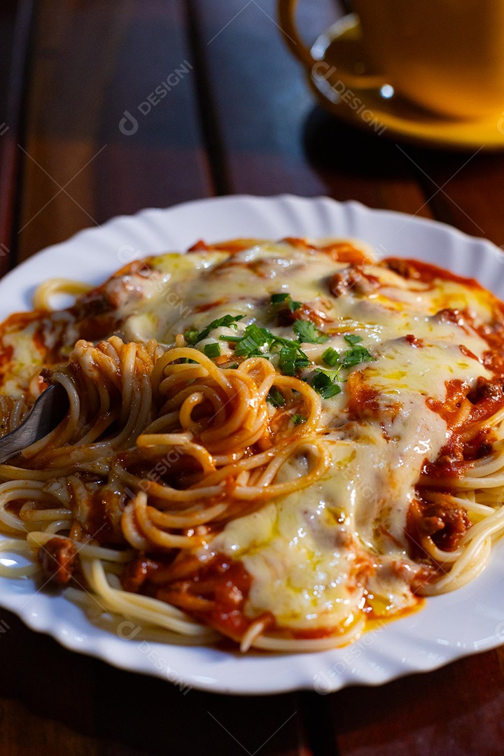 Um prato de espaguete gratinado com queijo