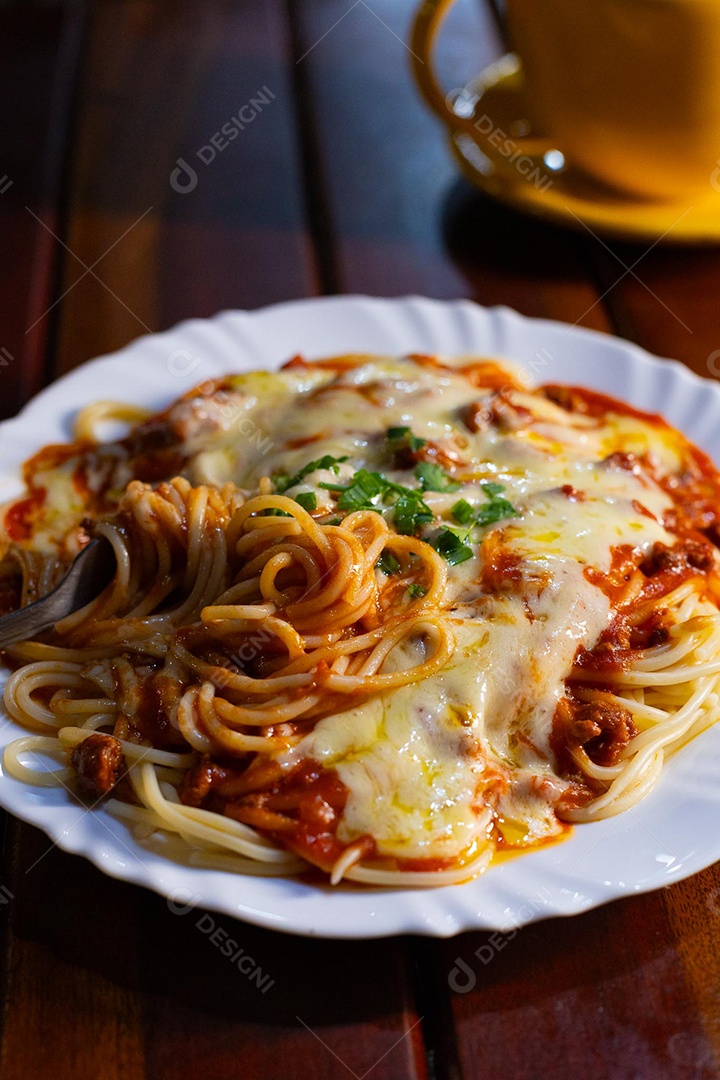 Um prato de espaguete gratinado com queijo