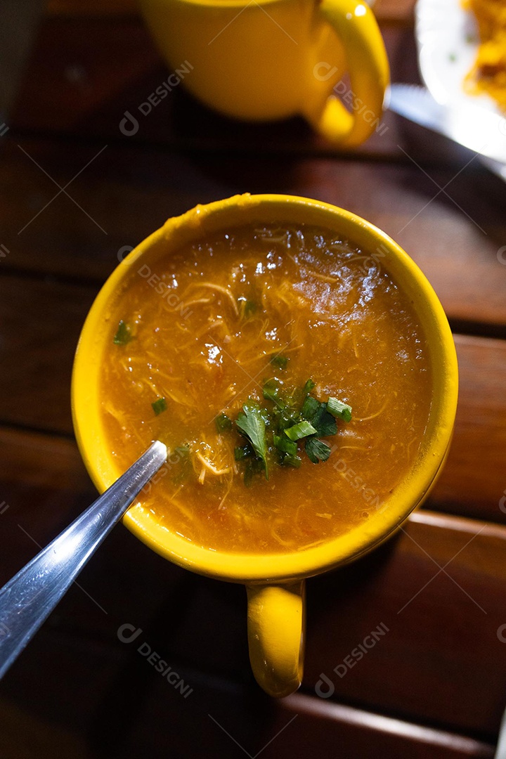 Xícara de sopa de lentilha sobre uma mesa de madeira