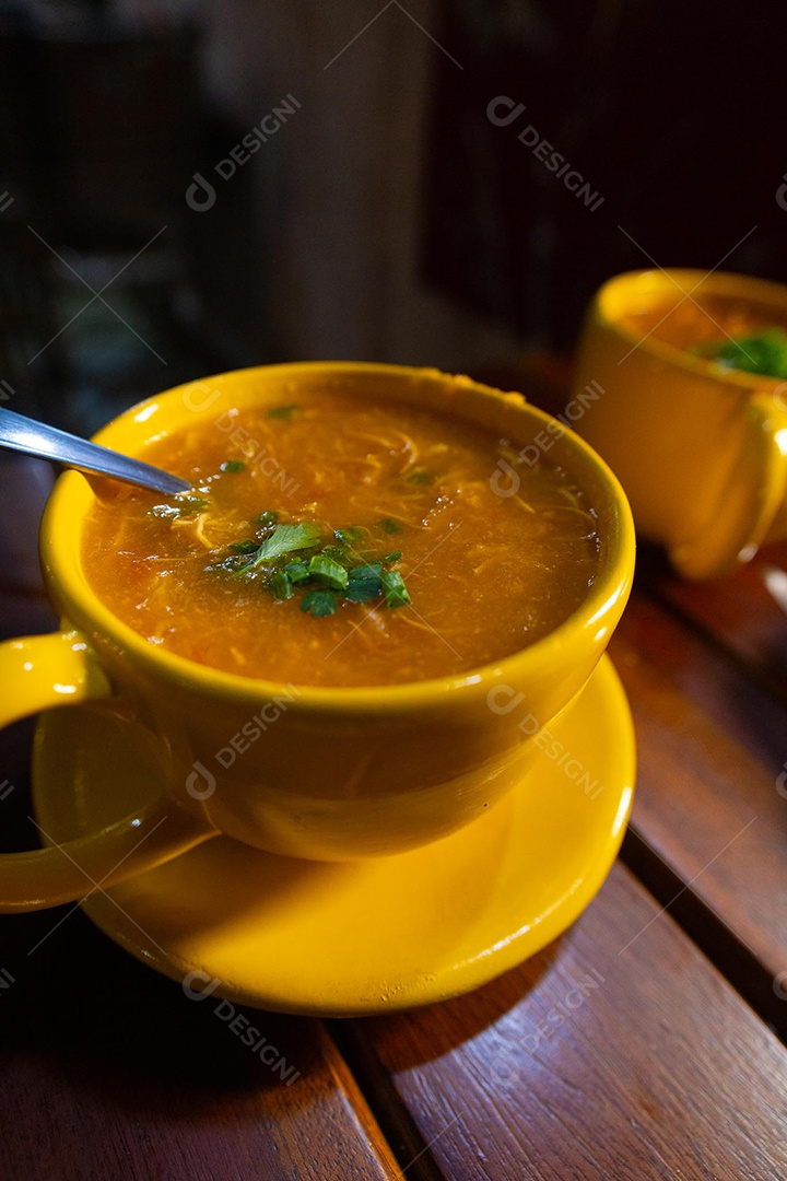 Xícara de sopa de lentilha sobre uma mesa de madeira