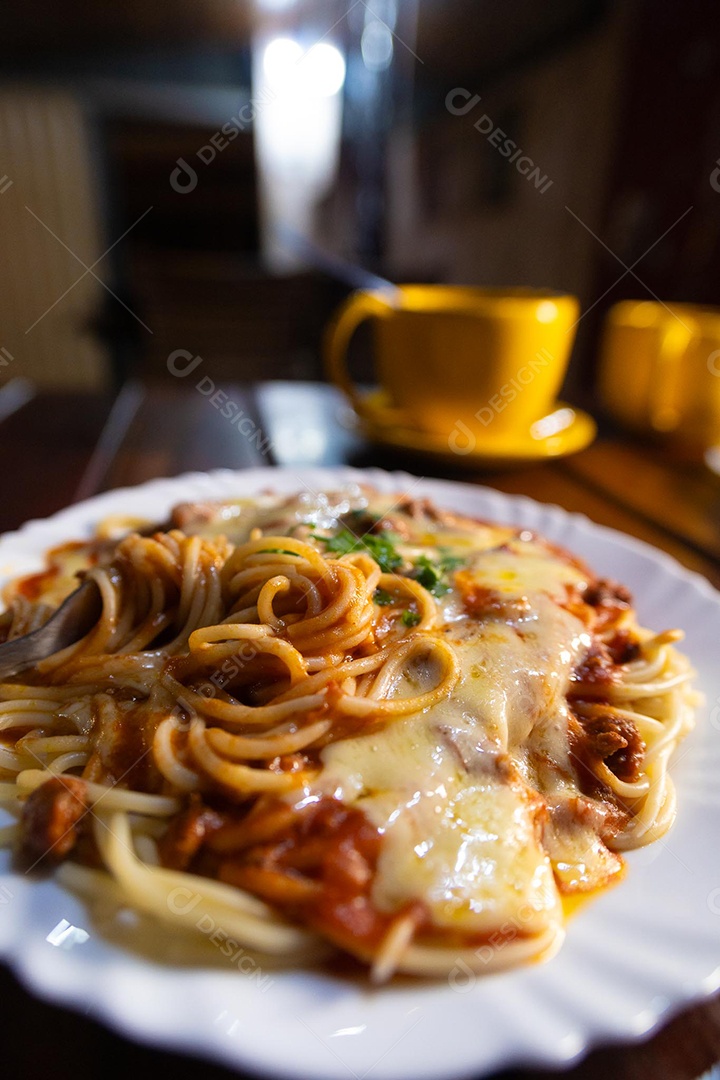 Um prato de espaguete gratinado com queijo