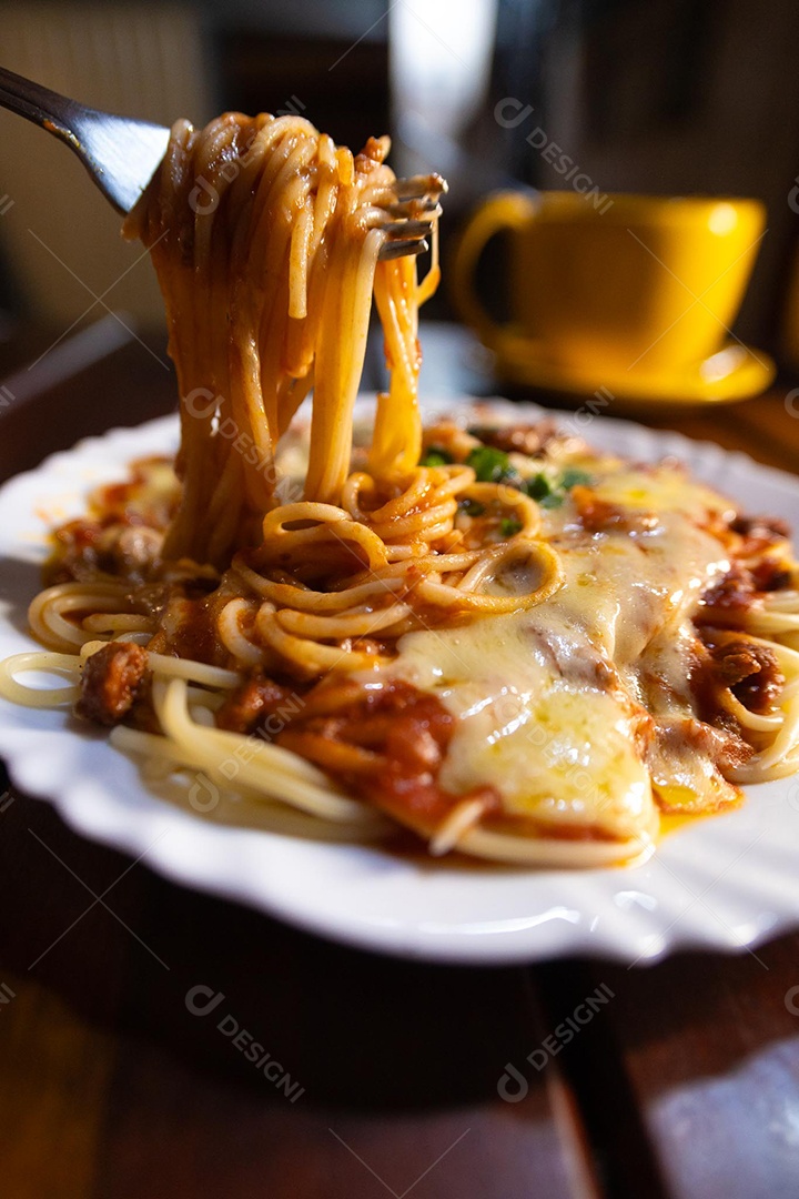 Um prato de espaguete gratinado com queijo