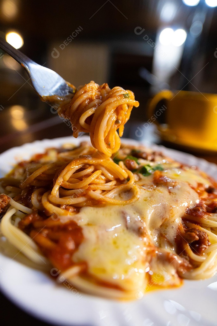 Um prato de espaguete gratinado com queijo