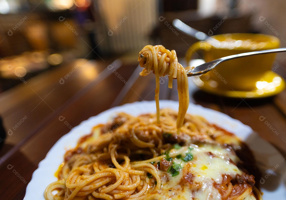 Um prato de espaguete gratinado com queijo