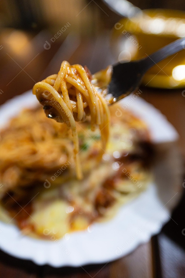 Um prato de espaguete gratinado com queijo