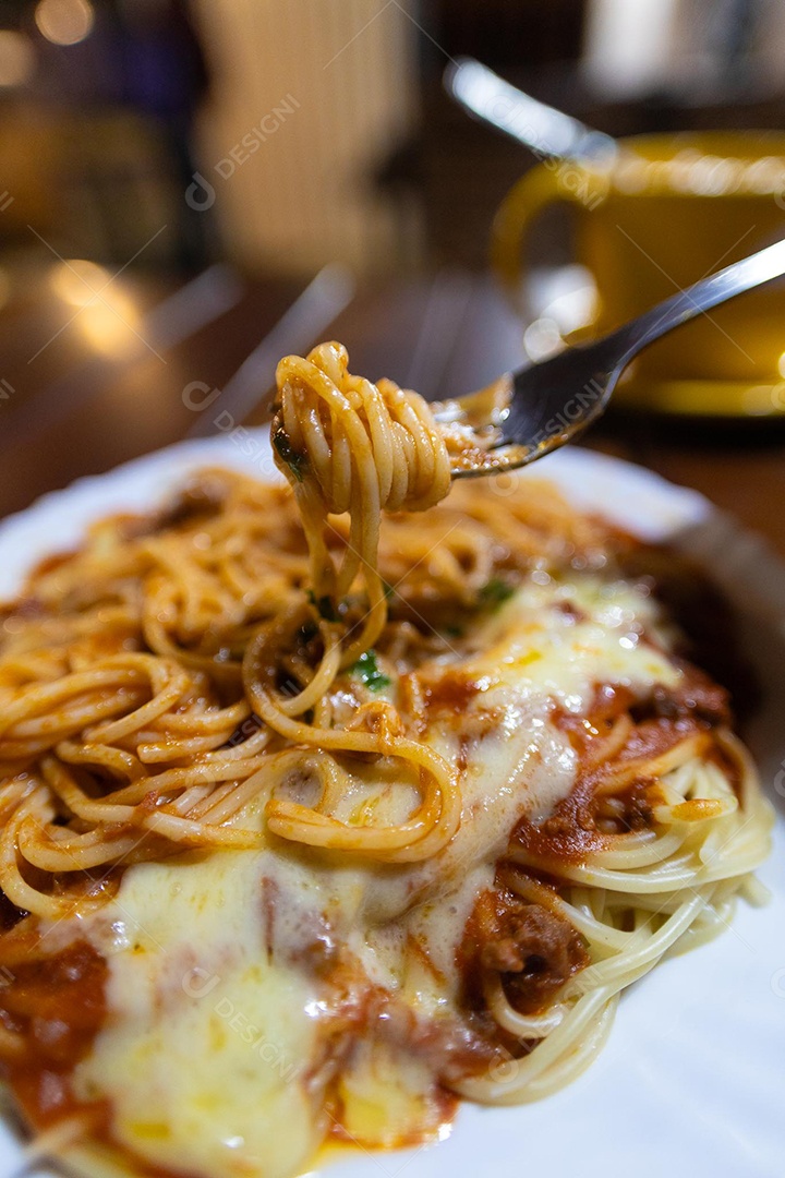 Um prato de espaguete gratinado com queijo