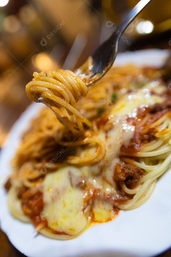 Um prato de espaguete gratinado com queijo