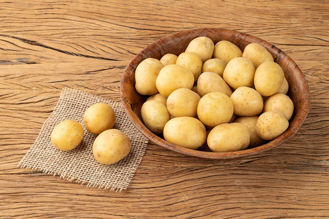 Pequenas batatas em uma tigela sobre a mesa de madeira