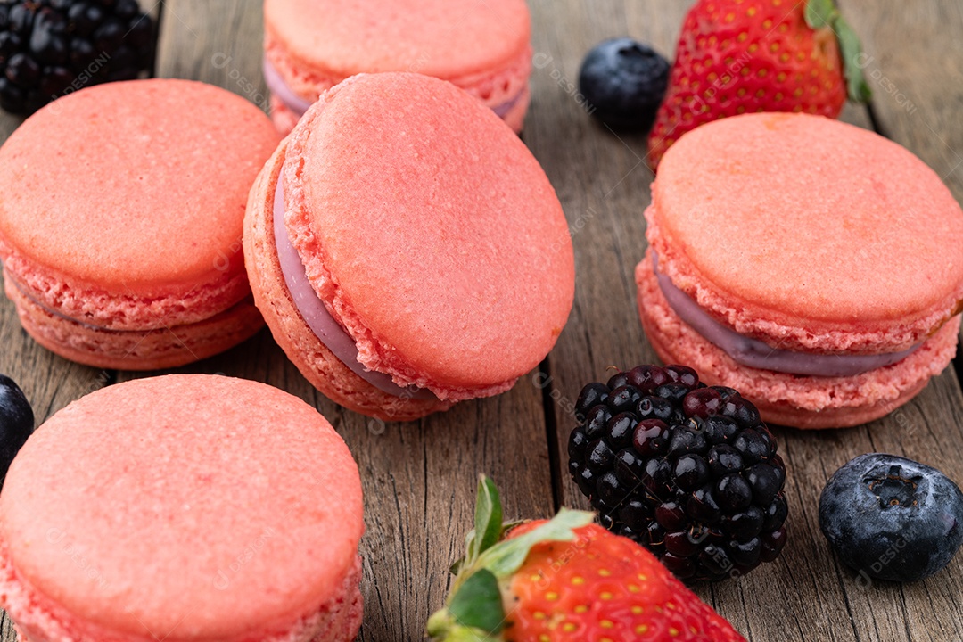 Macarons de frutas vermelhas sobre mesa de madeira