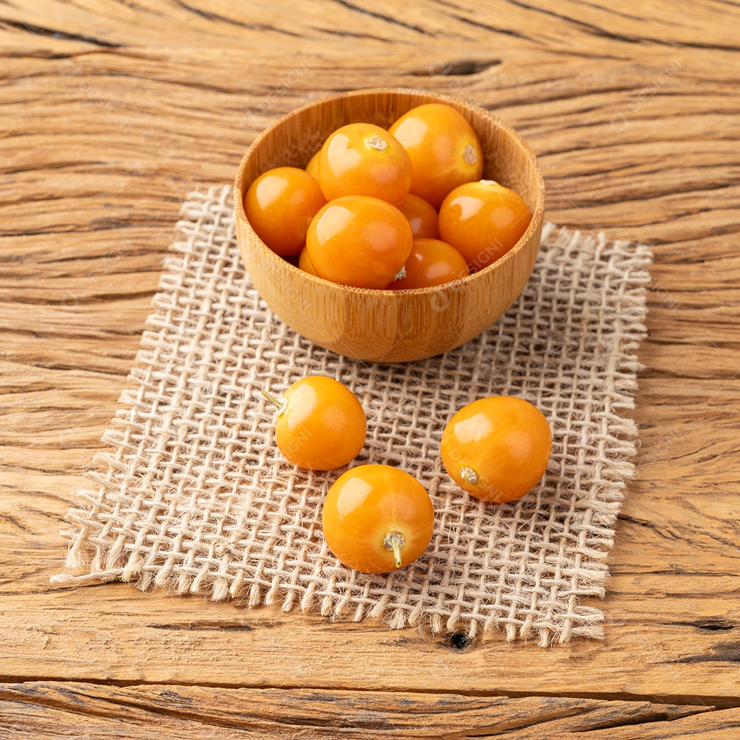 Physalis em uma tigela sobre uma mesa de madeira.