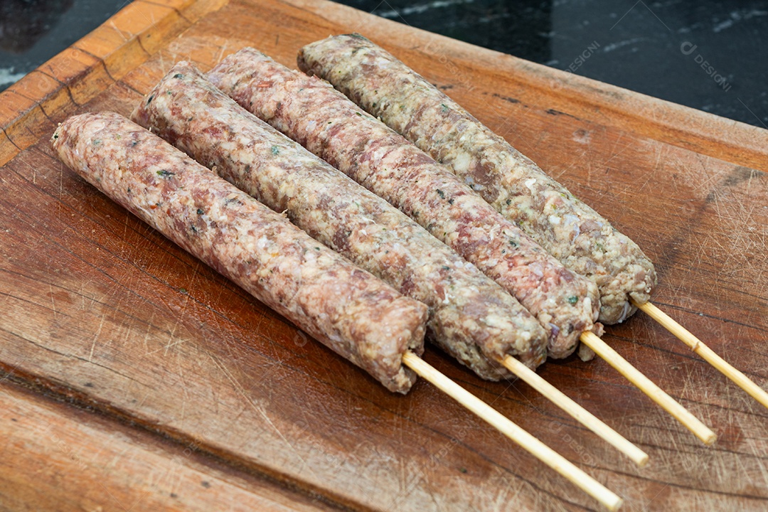 Espetinhos prontos sobre tábua de madeira
