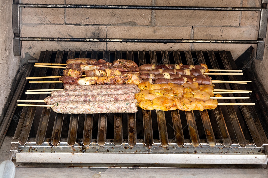 Espetinhos sendo grelhados na churrasqueira