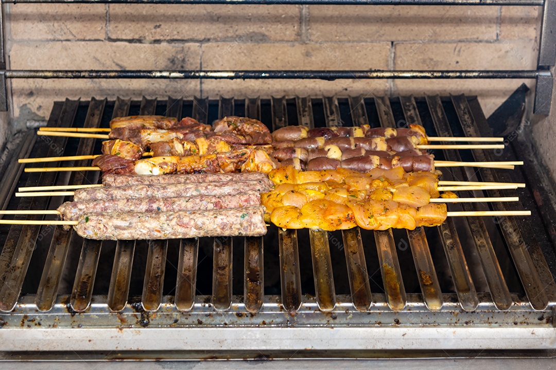 Espetinhos sendo grelhados na churrasqueira