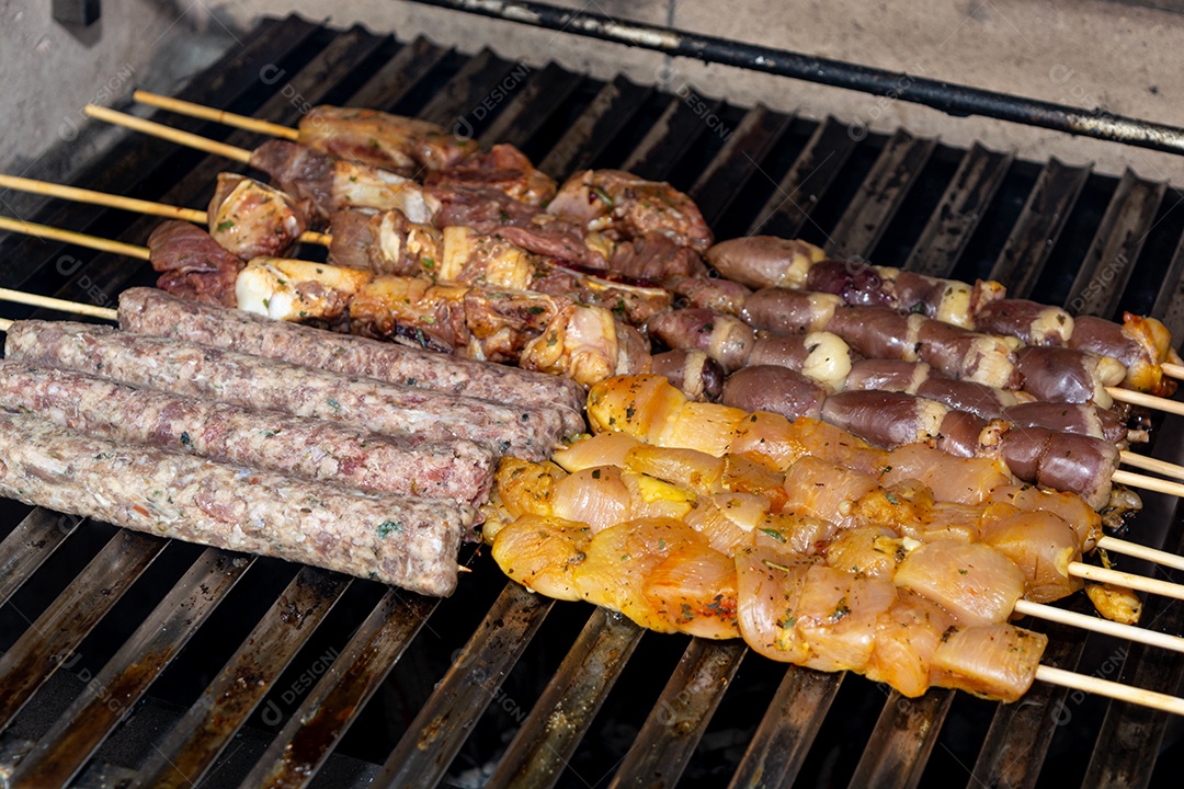 Espetinhos sendo grelhados na churrasqueira