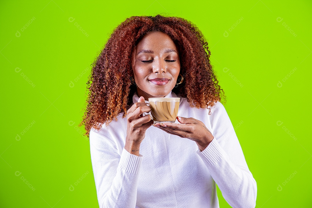 Mulher segurando xícara com cappuccino em fundo verde