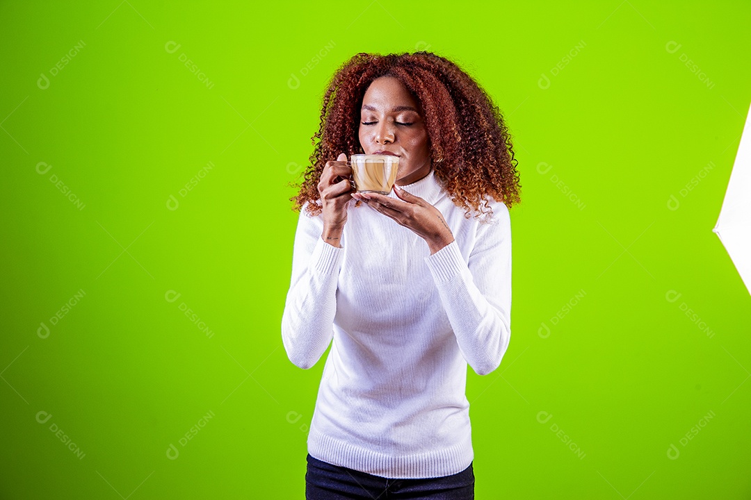 Mulher segurando xícara com cappuccino em fundo verde