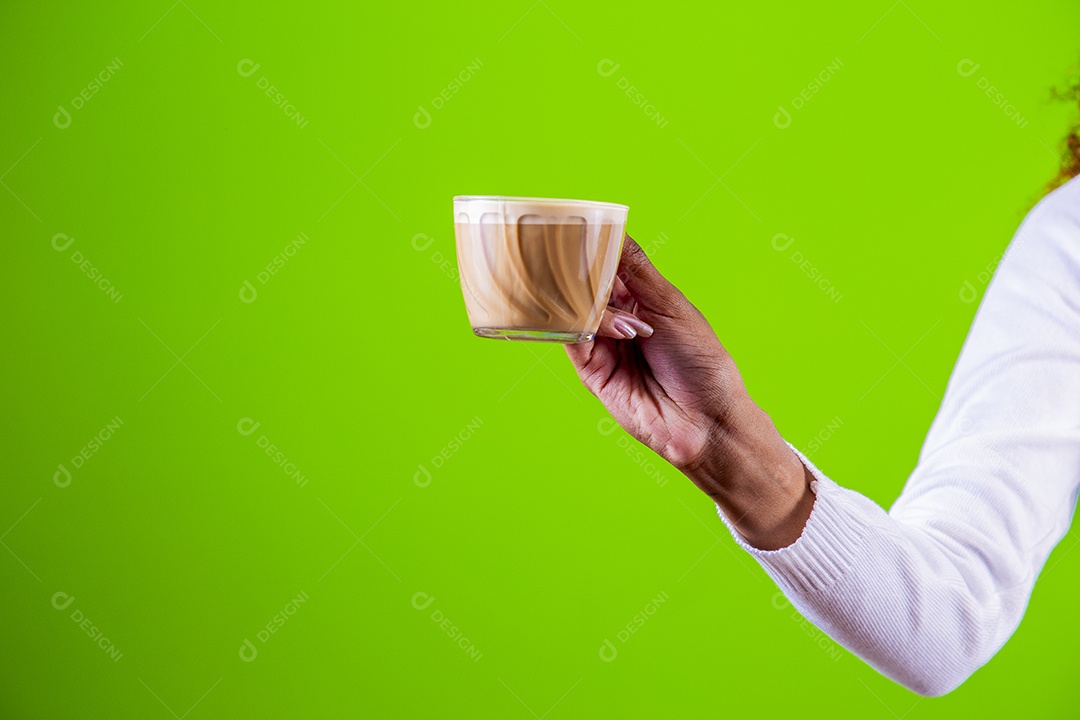 Mulher segurando xícara com cappuccino em fundo verde