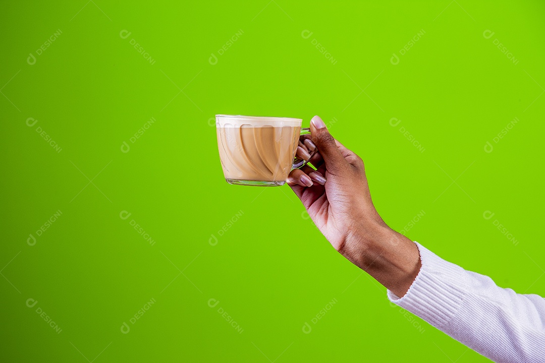 Mulher segurando xícara com cappuccino em fundo verde