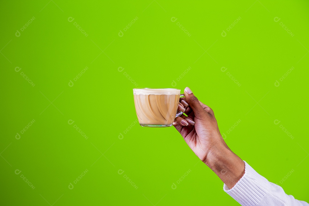 Mulher segurando xícara com cappuccino em fundo verde