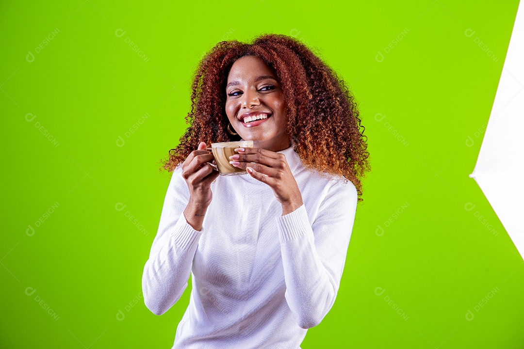 Mulher segurando xícara com cappuccino em fundo verde