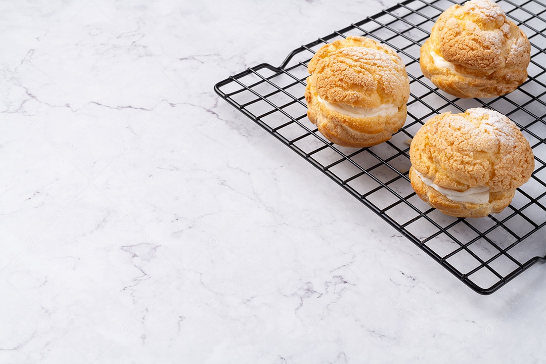 Creme choux, chantilly de baunilha recheado bolo sobre grade de metal com espaço de cópia.