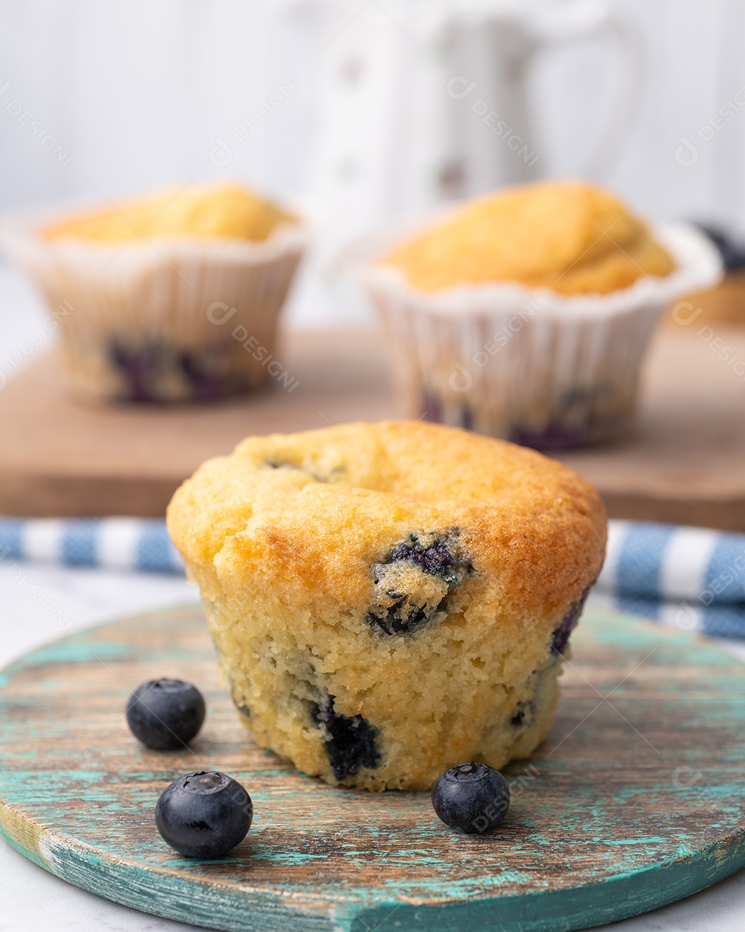Muffins de mirtilo com frutas sobre tábua de madeira.