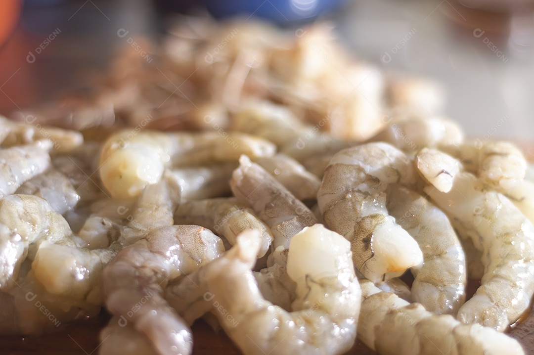Camarões frescos em uma tábua de madeira com luz natural