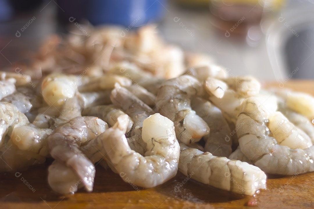 Camarões frescos em uma tábua de madeira com luz natural