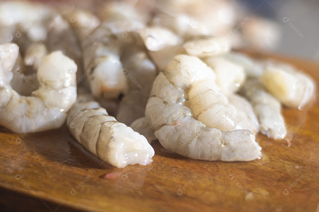 Camarões frescos em uma tábua de madeira com luz natural
