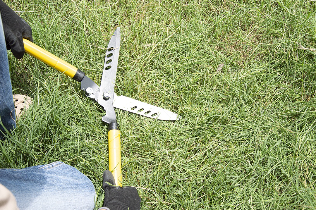 Tesouras de grama amarelas deitadas na grama