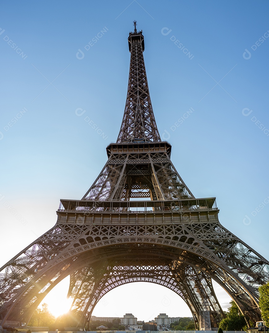 A Torre Eiffel vista através de árvores com um lindo céu de verão ao fundo, Paris, França