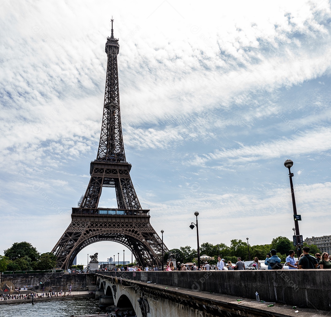 A Torre Eiffel vista através de árvores com um lindo céu de verão ao fundo, Paris, França