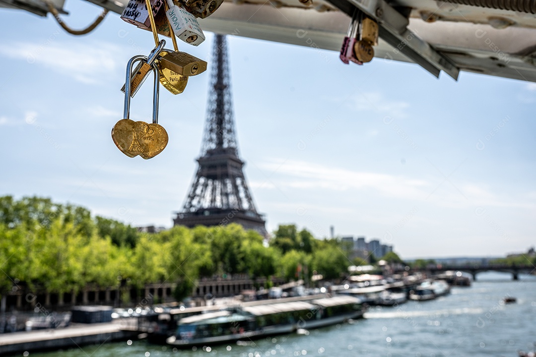 Detalhe de um cadeado de amor, com o Rio Sena e a Torre Eiffel ao fundo, em Paris, França.