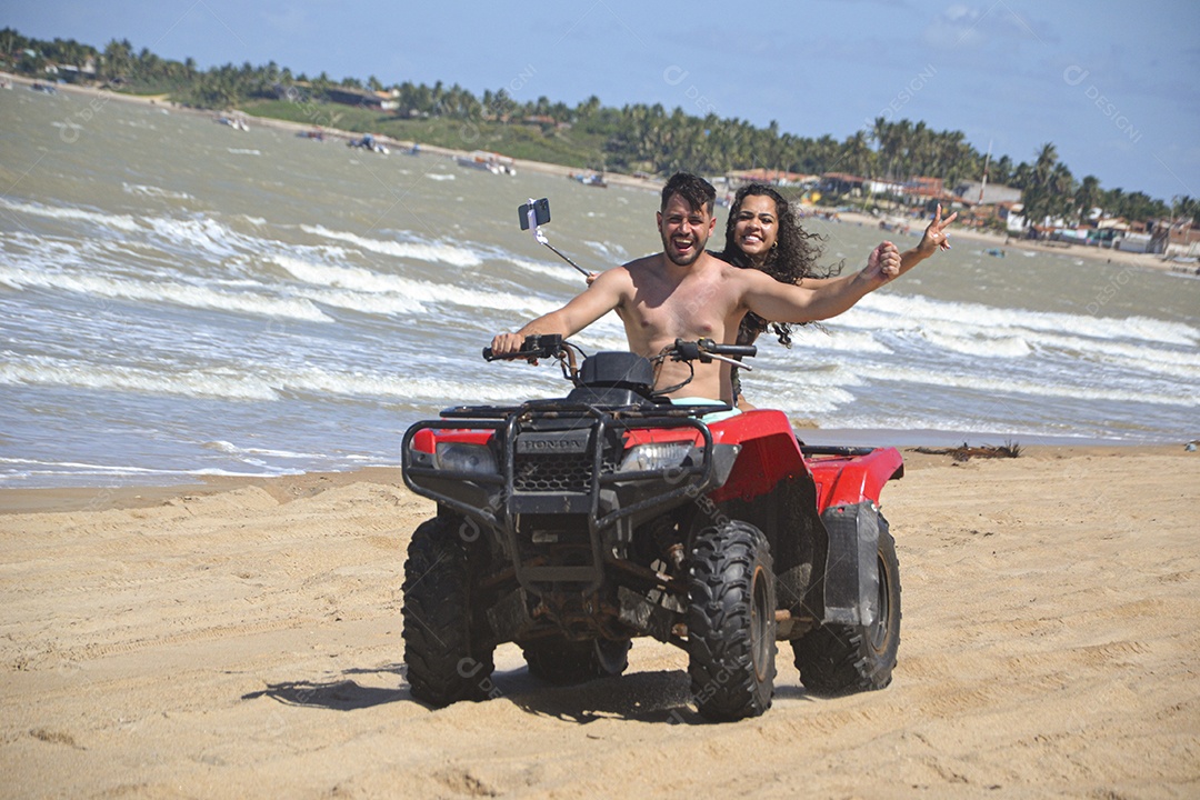 Família andando de quadriciclo pela praia