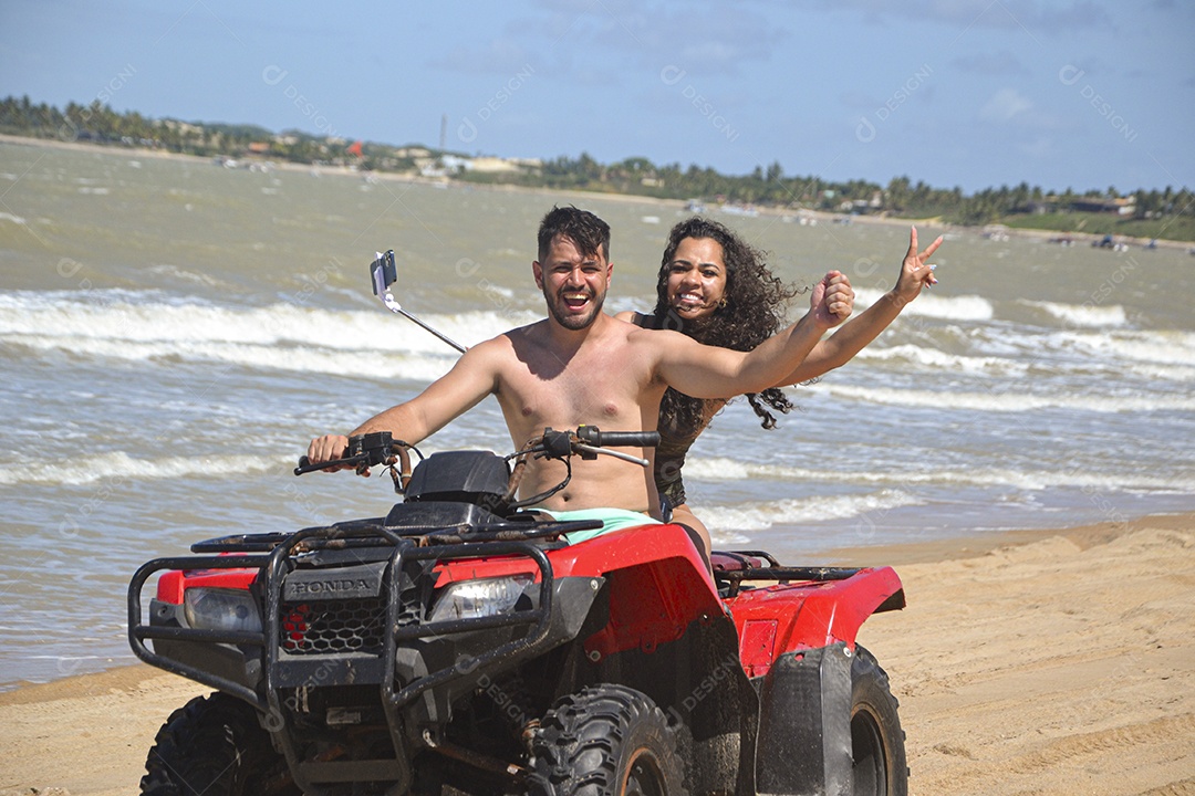 Família andando de quadriciclo pela praia
