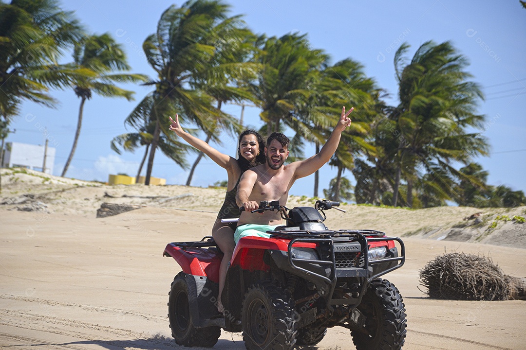 Família andando de quadriciclo pela praia