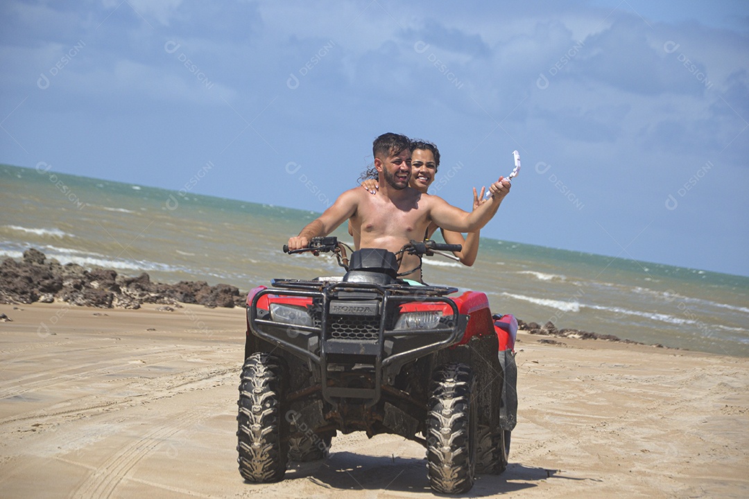 Família andando de quadriciclo pela praia