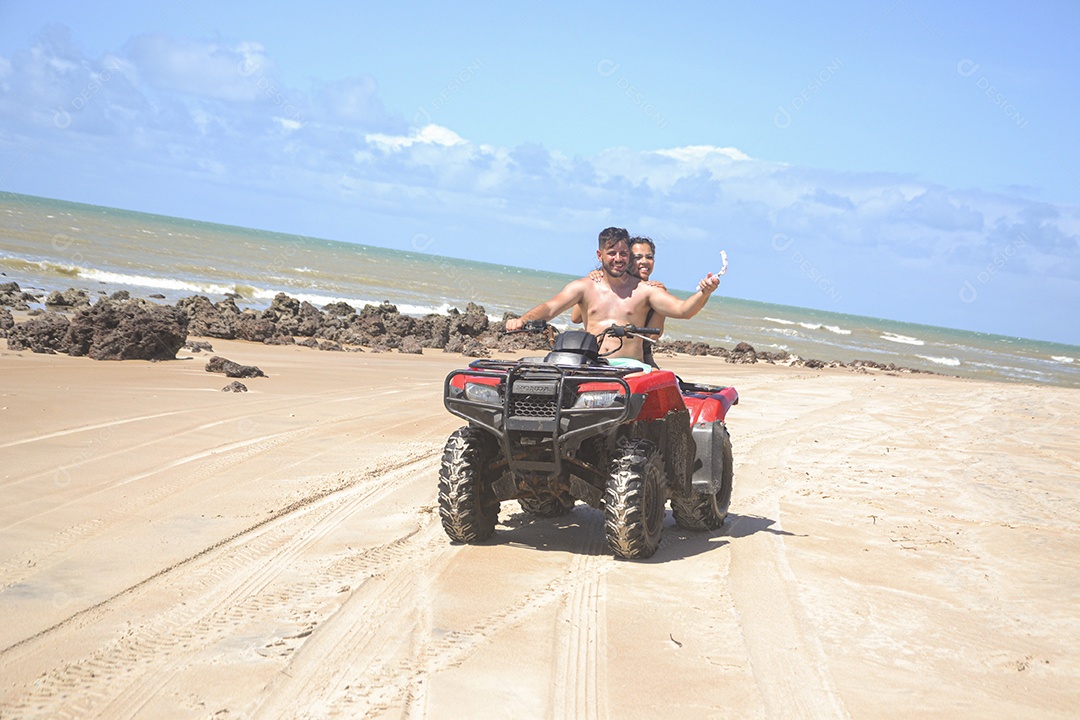 Família andando de quadriciclo pela praia