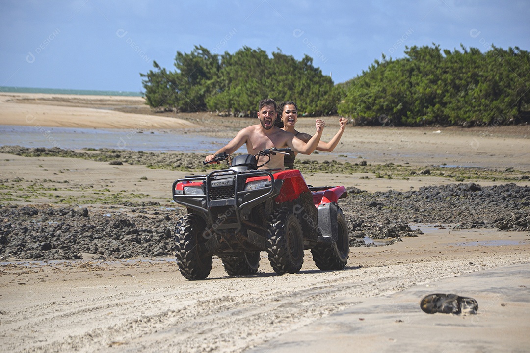 Família andando de quadriciclo pela praia