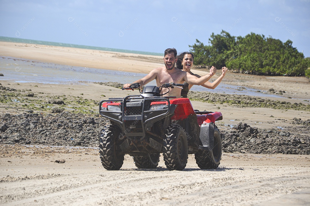 Família andando de quadriciclo pela praia