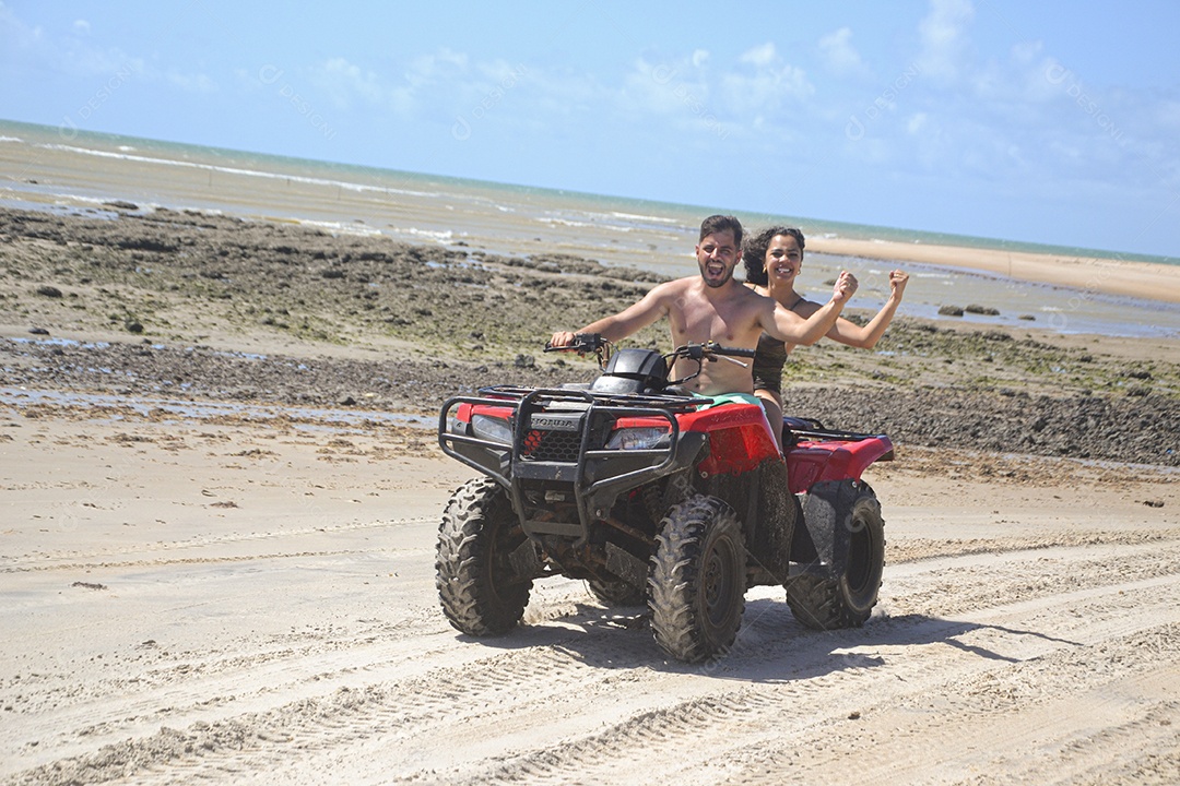Família andando de quadriciclo pela praia