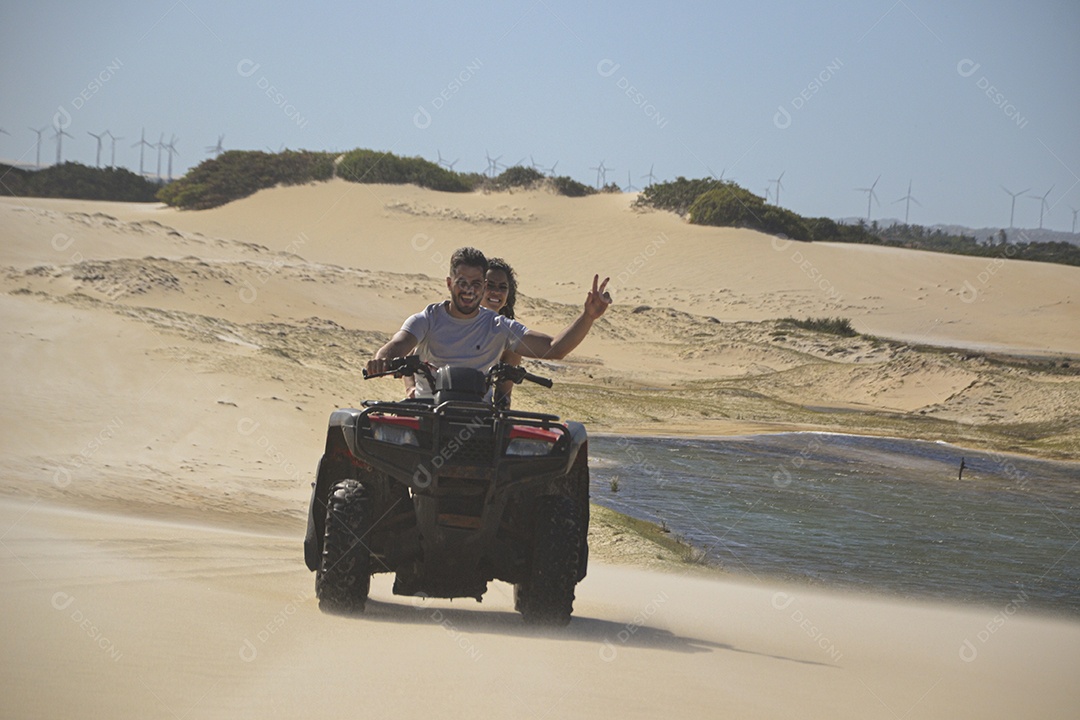 Casal feliz andando de quadriciclo na praia