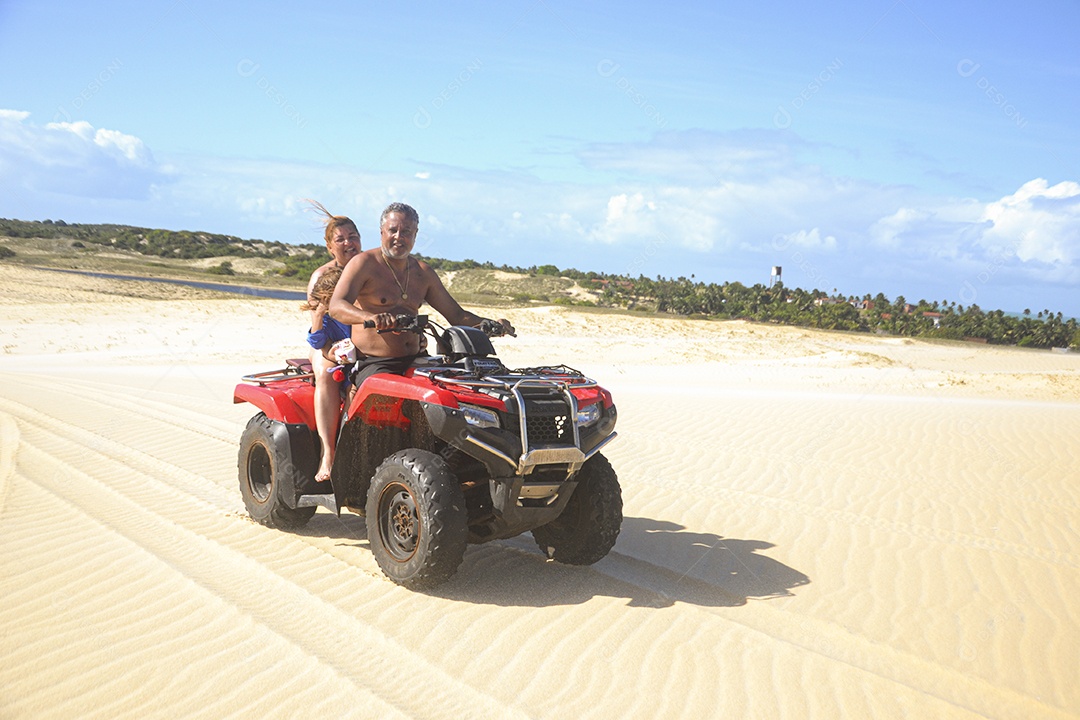 Casal feliz andando de quadriciclo na praia
