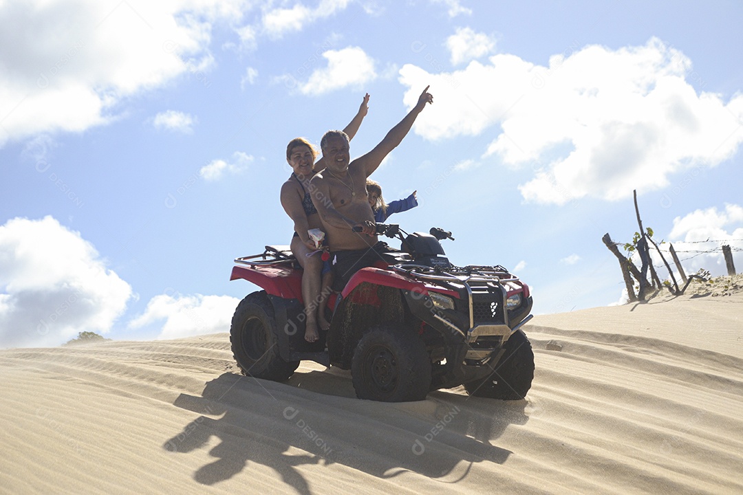 Casal feliz andando de quadriciclo na praia