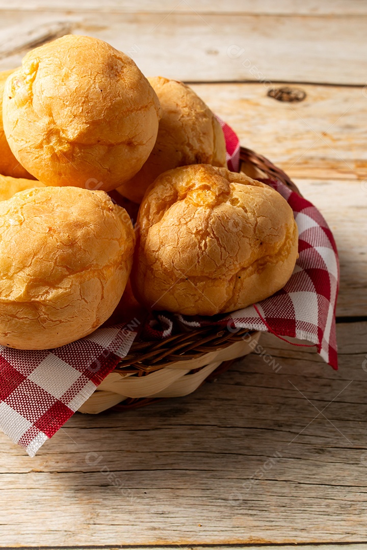 Pão de queijo em mesa de madeira com café preto