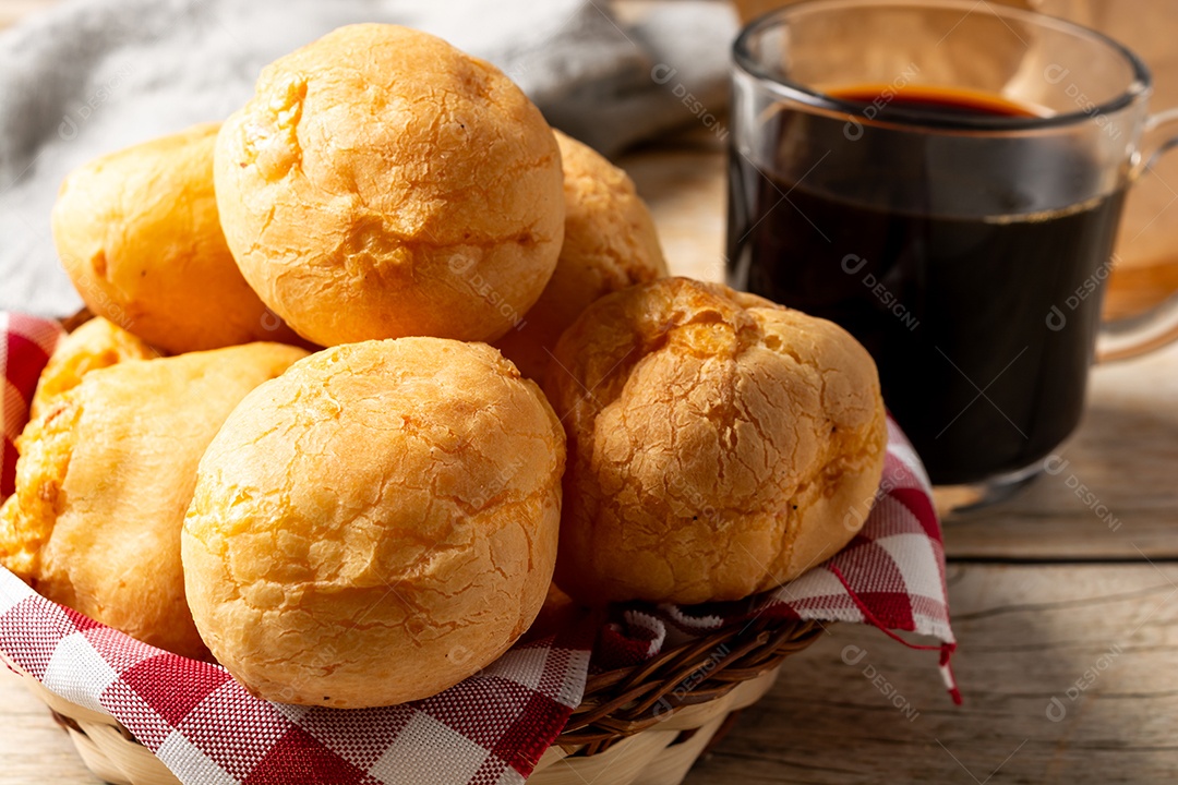 Pão de queijo em mesa de madeira com café preto