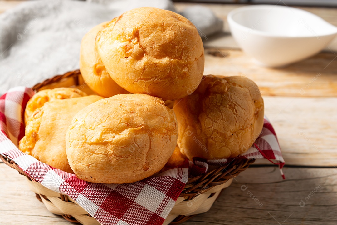 Pão de queijo em mesa de madeira com café preto