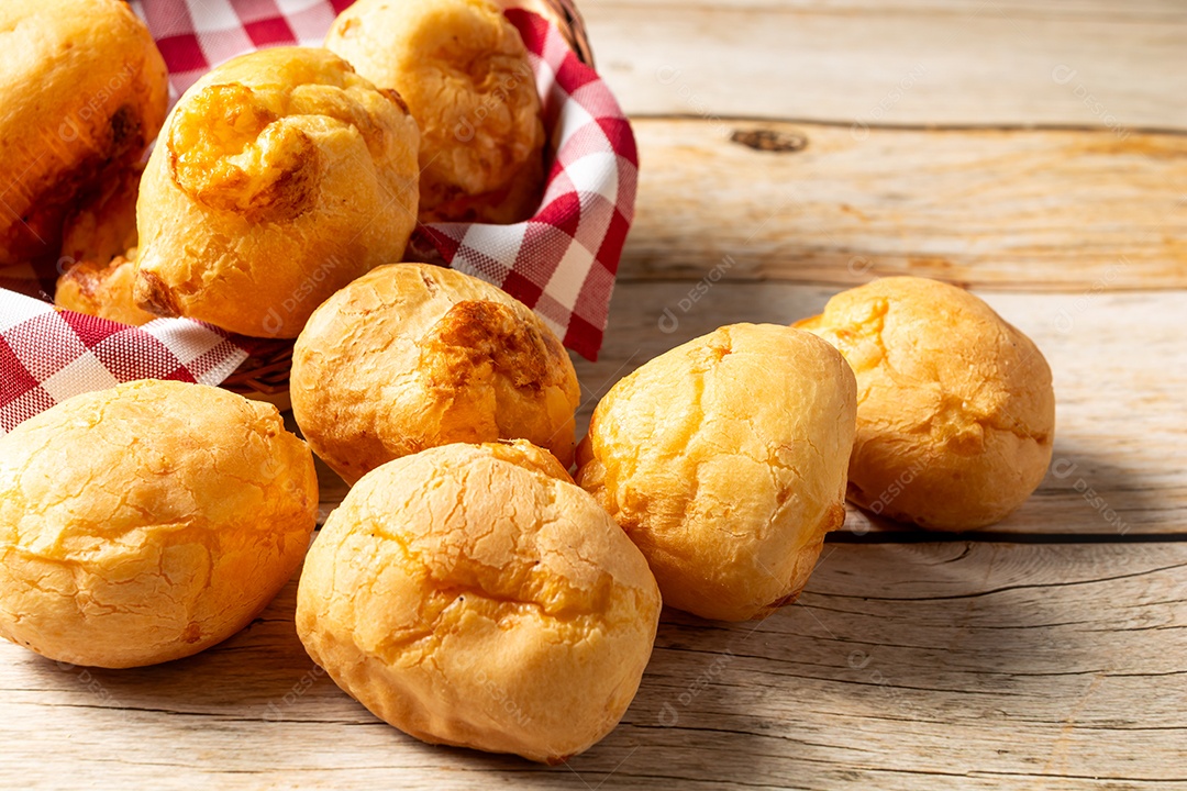 Pão de queijo em mesa de madeira com café preto