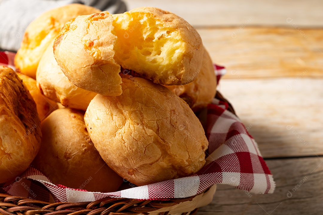 Pão de queijo em mesa de madeira com café preto