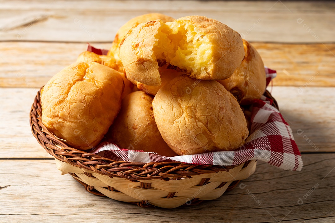 Pão de queijo em mesa de madeira com café preto